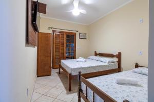 a bedroom with two beds and a flat screen tv at Pousada Cabeça do Indio - Trindade in Trindade