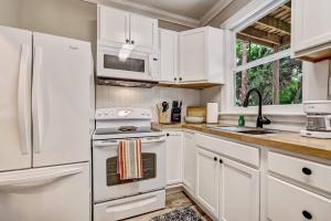 a kitchen with white cabinets and a white refrigerator at The White Len in Jacksonville