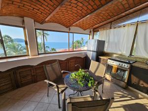 a kitchen with a table and chairs and the ocean at Villa Corona del Mar in Rincon de Guayabitos