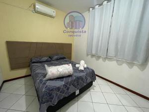 a bedroom with a bed with a stuffed animal on it at Apto Conquista Imóveis exclusivo para Booking in Vitória da Conquista