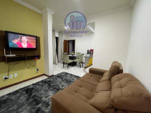 uma sala de estar com um sofá e uma televisão de ecrã plano em Apto Conquista Imóveis exclusivo para Booking em Vitória da Conquista