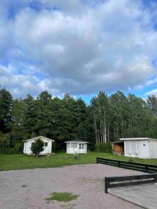 un grupo de tres edificios blancos en un parque en Villa Rosenfors, en Rosenfors