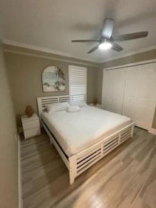um quarto com uma cama branca e uma ventoinha de tecto em Serenity at Moon Bay! em Key Largo