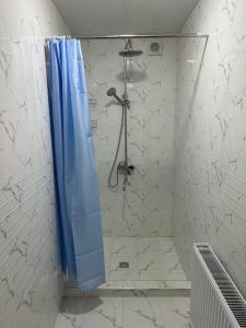 a shower with a blue shower curtain in a bathroom at Samarkand Hostel in Samarkand