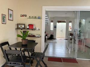 a dining room and living room with a table and chairs at Casa Brisas Arembepe - arejada e aconchegante - litoral norte da Bahia - WiFi in Arembepe