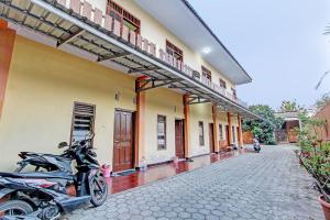 une moto garée devant un bâtiment dans l'établissement SPOT ON 93007 Guest House Lestari, à Prambanan