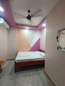 a small room with a bed with a ceiling at HOTEL ANJALI in Ujjain