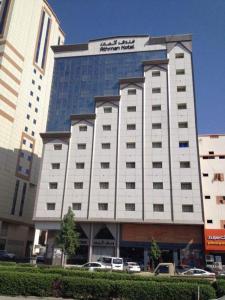فندق أثمان في مكة المكرمة: مبنى كبير فيه سيارات تقف امامه