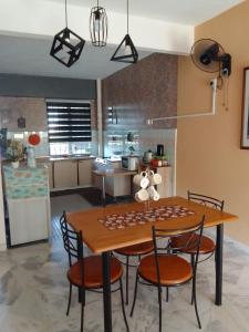 een keuken en eetkamer met een houten tafel en stoelen bij Homestay Anak Kito@Teluk Kemang Port Dickson in Port Dickson