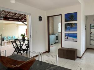 a living room with a table and chairs and a kitchen at Casa Brisas Arembepe - arejada e aconchegante - litoral norte da Bahia com crianca - WiFi in Arembepe