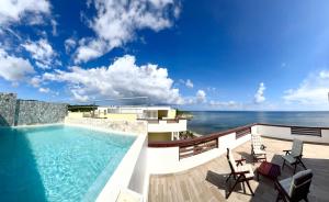 una piscina en el balcón de una casa con el océano en Condominio frente al mar Roatán, en Roatan