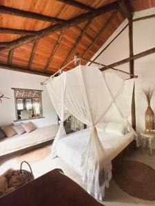 1 dormitorio con 1 cama con mosquitera en Casa Mar Pé na Areia, en Caraíva