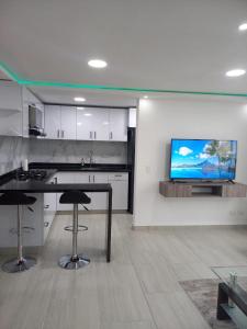 een keuken met een tafel en een tv aan de muur bij Apartamento nuevo en Barranquilla in Barranquilla