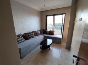 a living room with a large couch and a window at Appartement beau lieu plage Manisman in Mohammedia