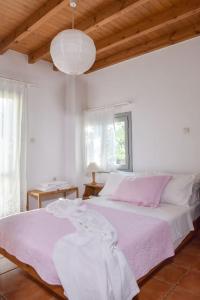 カラマキにあるSeasound houseの白いベッドルーム(ピンクのシーツが備わる大型ベッド付)