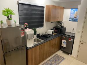 uma cozinha com um frigorífico de aço inoxidável e um lavatório em Reylin Alanis Suite // Free Wifi & Netflix // Airport Shuttle Service em Sepang