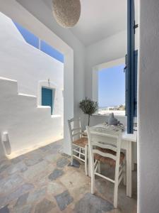 una sala da pranzo bianca con tavolo e sedie di Alexandros Apartments a Naoussa