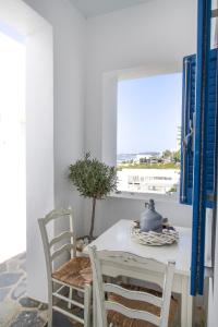 einen weißen Tisch und Stühle in einem Zimmer mit Fenster in der Unterkunft Alexandros Apartments in Naoussa