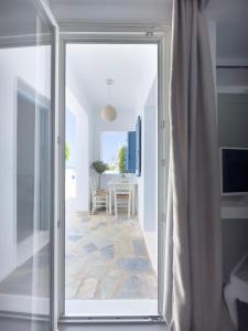una porta a vetri che conduce a una sala da pranzo con tavolo di Alexandros Apartments a Naoussa
