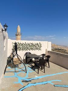 eine Terrasse mit einem Tisch, Stühlen und einem Leuchtturm in der Unterkunft Tarihi kent ev in Mardin