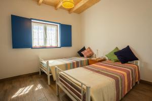 a bedroom with two beds and a window at Tia Antonia 