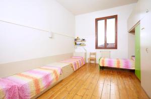 Cette chambre comprend 2 lits et une fenêtre. dans l'établissement Ostello AMDG, à Venise