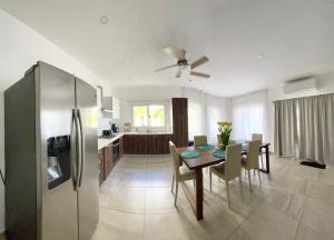a kitchen and dining room with a table and a refrigerator at Condominio frente al mar Roatán in Roatan