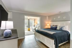 1 dormitorio con 1 cama grande y espejo en St Simons Island Condo on Golf Course Near Beach!, en Harrington