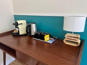a table with a coffee maker and a lamp on it at Guest house close to Disney! in Montévrain