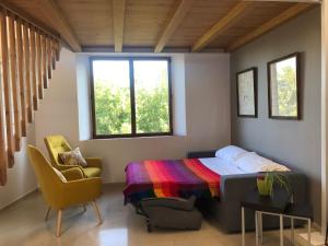 a bedroom with a bed and a chair and two windows at Antiga Biblioteca in Solsona