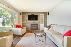 sala de estar con sofá y chimenea en Lakefront Chippewa Falls Haven with Private Deck!, en Chippewa Falls