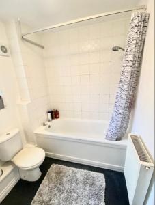 a bathroom with a white tub and a toilet at Barons Place in Birmingham