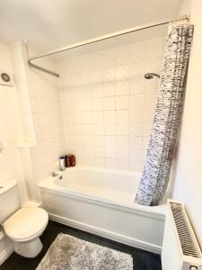 a bathroom with a white tub and a toilet at Barons Place in Birmingham