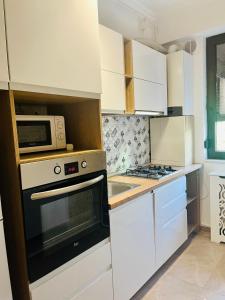 uma cozinha com um micro-ondas e um fogão em Solid Residence Apartments Mamaia em Mamaia