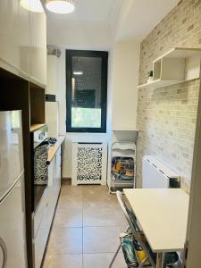 uma cozinha com electrodomésticos brancos e uma parede de tijolos em Solid Residence Apartments Mamaia em Mamaia