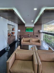 uma sala de estar com um sofá e uma mesa em Tropical Barra Hotel no Rio de Janeiro
