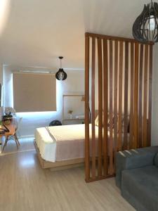 um quarto com uma cama e um berço de madeira em LOFT aconchegante no Centro de Macaé, Wifi, Ar condicionado e Cozinha completa em Macaé
