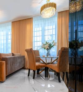 Un comedor con una mesa y sillas y un sofá. en Apartament Versace Jana Pawła, en Wroclaw
