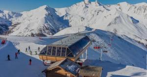 une montagne enneigée avec un lodge de ski sur une piste de ski dans l'établissement Studio cosy 5 personnes, à Saint-Lary-Soulan