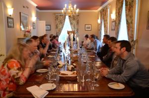 a group of people sitting at a long table at Delphi Lodge in Leenaun