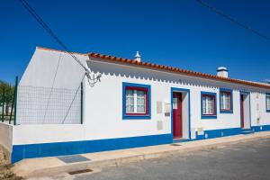 a white and blue house with red doors on a street at Tia Antonia 