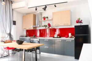 a kitchen with red walls and a black refrigerator at Joanna 1 Apartment with Parking in Larisa