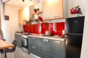 a kitchen with red cabinets and a black refrigerator at Joanna 1 Apartment with Parking in Larisa +18 photos