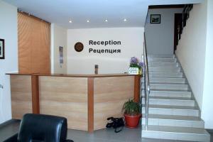 a reception desk in a lobby with a staircase at Interrum Hotel in Razgrad