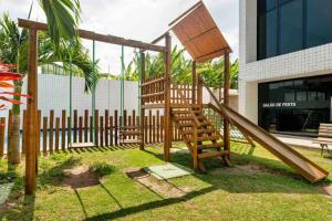 um parque infantil de madeira com um escorrega em frente a um edifício em Coração de Boa Viagem em Recife