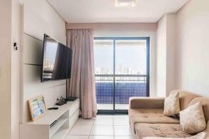 ein Wohnzimmer mit Couch und großem Fenster in der Unterkunft Coração de Boa Viagem in Recife