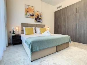 a bedroom with a large bed with yellow pillows at Key View - Orchid Residence in Dubai