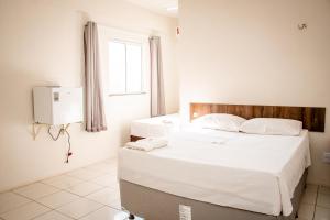 a bedroom with two beds and a window at Letiva Hotel Centro in Sobral