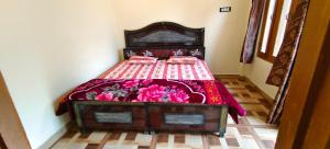 a bedroom with a bed with pink flowers on it at hotel chakrata green and camping in Chakrāta