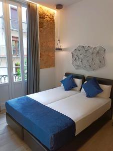 een slaapkamer met een groot bed met blauwe kussens bij Hotel El Siglo in Valencia